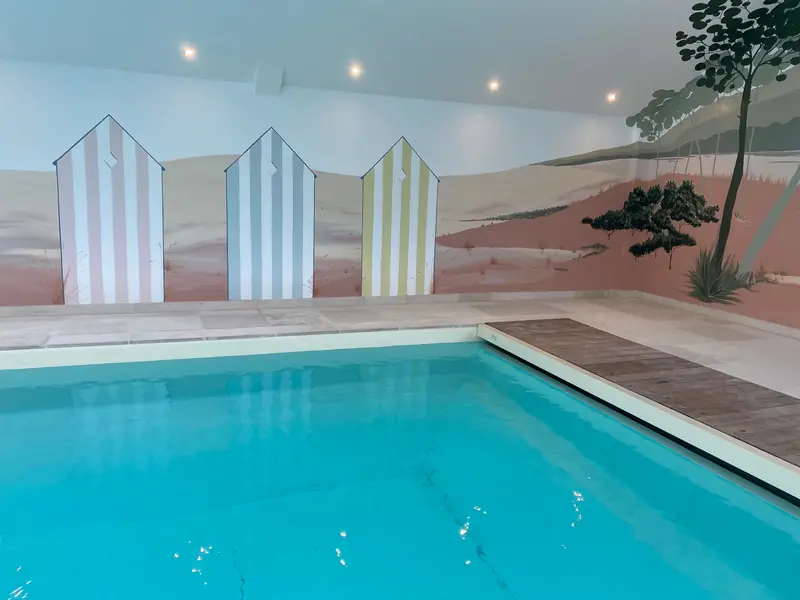 Cabines de plage rayées peintes au-dessus d'une piscine