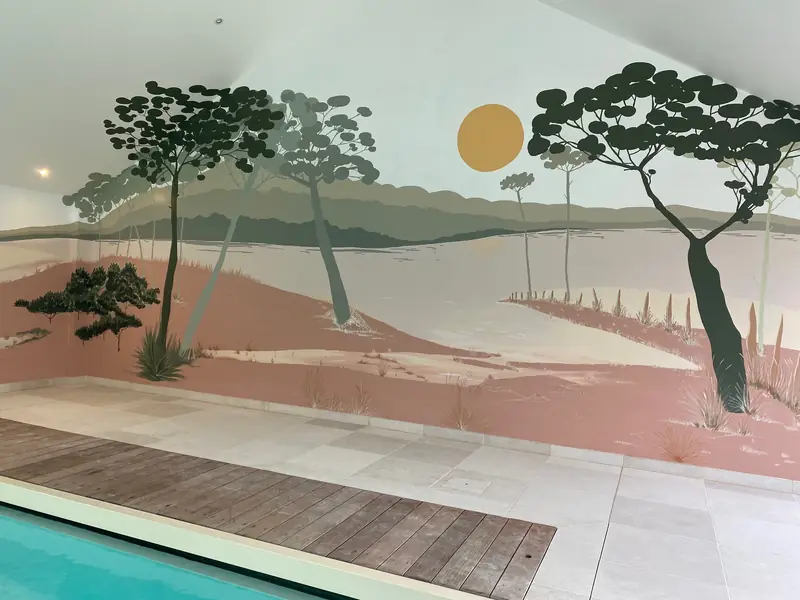 Fresque murale de pins parasols et de dunes rosées autour d'une piscine intérieure